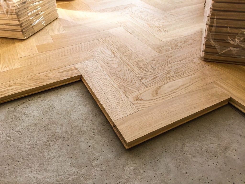 Wood parquet flooring being laid on a kitchen floor
